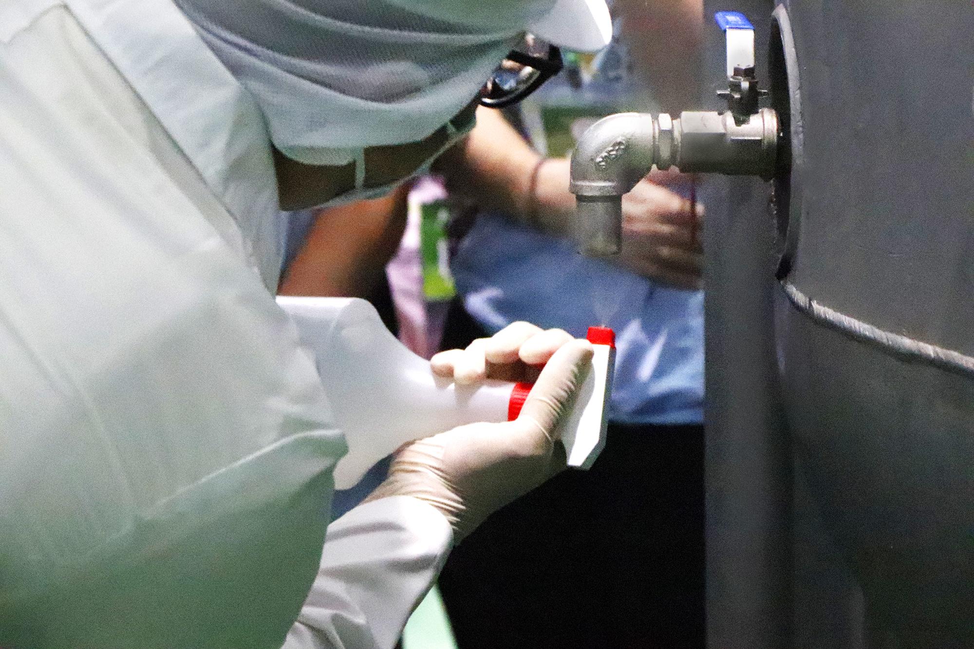 宇洋生醫酵素廠人員示範取樣前的消毒動作